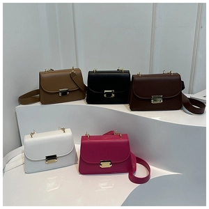 Five assorted colors of minimalist crossbody bags displayed on minimalist white stairs