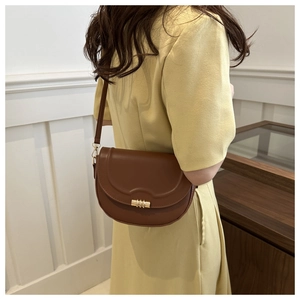 Braune Satteltasche aus Leder mit goldener Schnalle als Umhängetasche zu gelbem Kleid