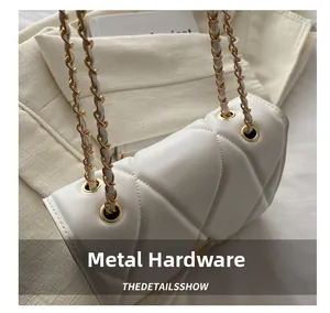 Detailed close-up of gold chain hardware and quilted texture on white leather bag