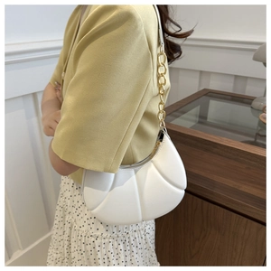 Detail of white pleated crescent bag with gold chain strap and soft PU leather texture