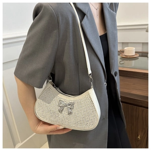 Detail of silver rhinestone shoulder bag featuring a metallic butterfly bow accent