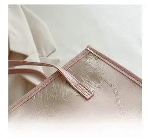 Close-up of pink jacquard fabric with floral embroidery and high-quality leather edging
