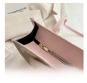 Detail view of the smooth metal zipper and white lace embroidery on a pink tote bag