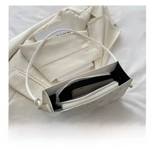 Quilted white crossbody phone bag showing interior storage for a smartphone