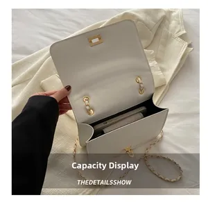 Interior view showing capacity of the white chain bag with smartphone and wallet