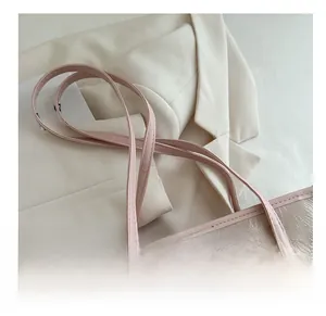 Detail of pink embroidered tote bag showing leather handle and fine floral stitching