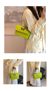 Détail du sac matelassé vert citron avec bandoulière chaîne et boucle papillon argentée
