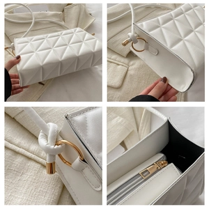 Detailed view of white quilted crossbody bag with gold hardware and knotted strap details