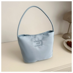 Detailed close-up of light blue nylon bag featuring onwards and upwards embroidery
