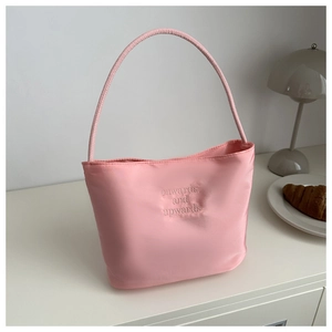 Detailed view of pink nylon handbag featuring embossed onwards and upwards embroidery