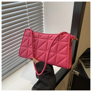 Detail of rose pink quilted crossbody bag with golden hardware and triangle stitching