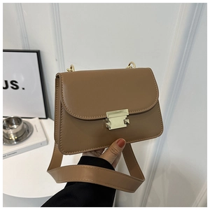 Close-up of caramel brown leather bag featuring a gold metal buckle and wide strap