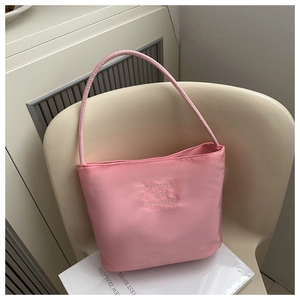 Detail of pink satin bucket bag featuring onwards and upwards embossed embroidery