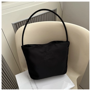 Detail of black nylon bucket bag with 'onwards and upwards' embossed lettering