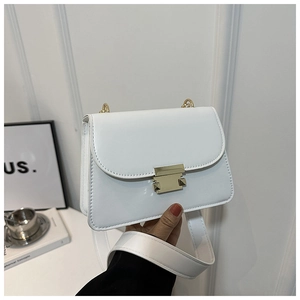 Detail of white square crossbody bag showing gold buckle and wide leather shoulder strap