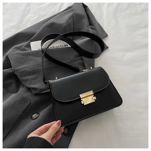 Close-up of black PU leather crossbody bag with golden buckle and textured finish