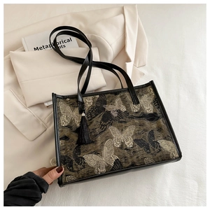 Détail de broderie papillon élégante et gland sur le grand sac cabas noir