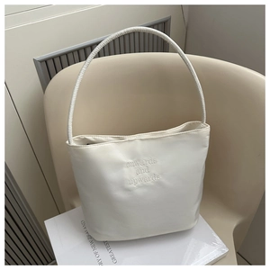 Detail of creamy white hobo bag with embossed onwards and upwards lettering