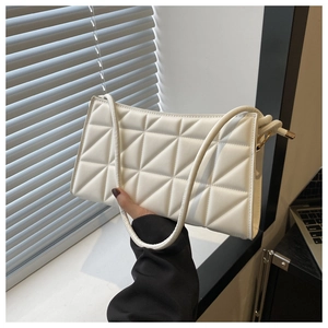 Detailed view of white crossbody bag with geometric quilted pattern on textured PU leather