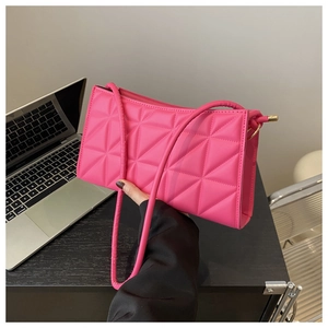 Detail of rose red quilted crossbody bag with geometric stitching and gold zipper hardware