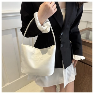 Close-up of white shoulder bag with onwards and upwards embroidery for a minimalist look