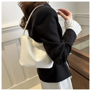 Close-up of white shoulder bag featuring elegant Onwards and Upwards embroidery detail