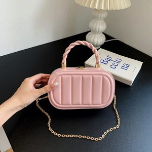 Borsa capsule trapuntata rosa con tracolla a catena dorata e manico in ambiente chic