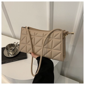 Detail of beige quilted crossbody bag with geometric stitching and slim shoulder strap