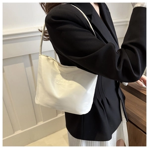 Detail of white tote bag featuring 'onwards and upwards' embroidery and thin strap