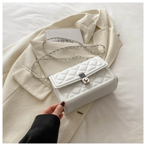 Detail of white quilted leather texture with classic silver chain strap and metal buckle