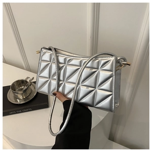Detail showing silver quilted geometric texture and metallic finish of the crossbody bag