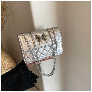 Détail du sac bandoulière argenté avec fermoir papillon en métal et chaîne