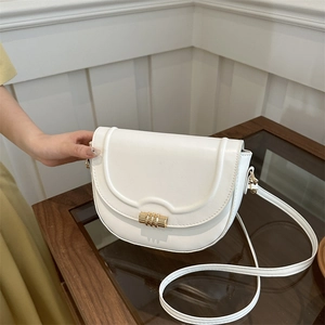 Minimalist white saddle shoulder bag with golden cylindrical metal clasp and long strap