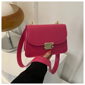 Detail of hot pink leather bag with golden square rivet buckle and long shoulder strap