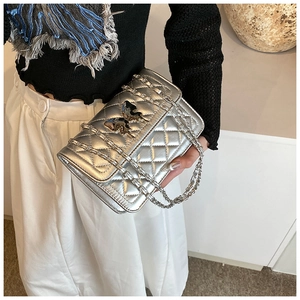 Détail du sac à chaîne matelassé argenté avec finition métallique et boucle papillon