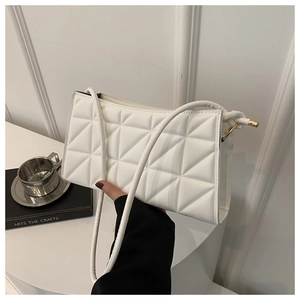 Detail of white quilted crossbody bag with modern geometric stitching and slim strap
