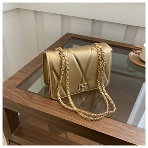 Detail of V-quilted faux leather texture and gold chain strap on an elegant crossbody bag