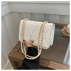 Detailed view of the white quilted leather texture and gold metal chain strap of the bag