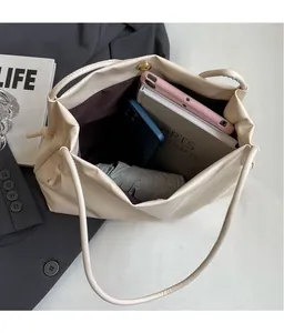 Dettaglio dell'interno capiente della borsa tote beige con grande spazio di carico