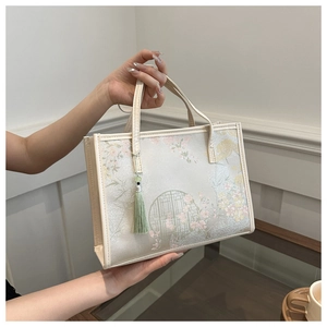 Détail d'un sac cabas floral avec imprimé oriental et pendentif à pampille verte