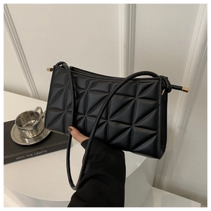 Detail view of black geometric quilted phone bag with elegant gold metal top bar