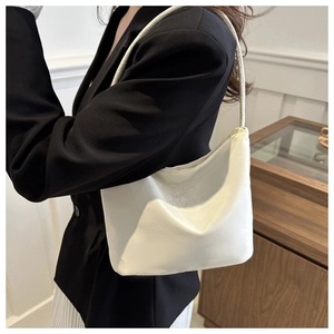 Detail of white PU leather bag with minimalist onwards and upwards embroidery on the surface