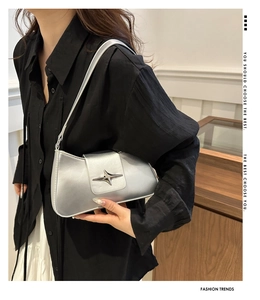 Detail of silver Y2K shoulder bag with metal star buckle and stylish slim strap