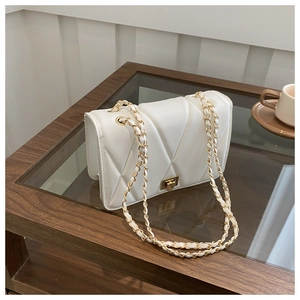 Detail of white quilted leather crossbody bag with gold chain strap and rotary lock