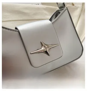 Detail of silver matte shoulder bag featuring a unique star-shaped metal buckle on the flap