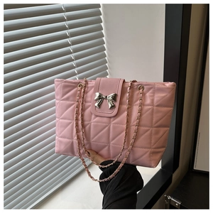 Detail view of pink quilted tote bag with silver bow buckle and gold chain strap