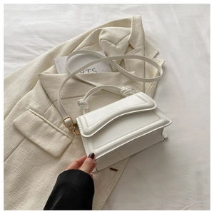 Detail view of white leather handbag with knotted handle and elegant stitching