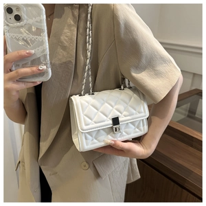 Detail of white quilted crossbody bag with silver square lock and chain strap