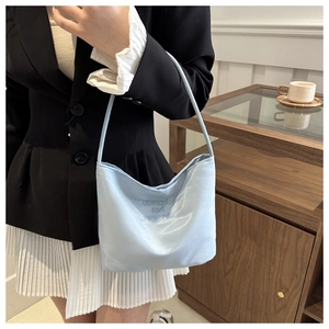 Macro shot of light blue satin shoulder bag featuring onwards and upwards embroidery detail