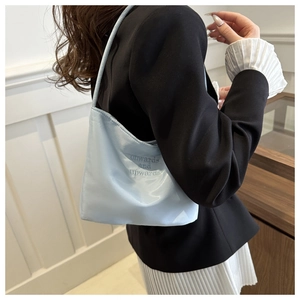 Detail of light blue satin underarm bag featuring onwards and upwards embroidery
